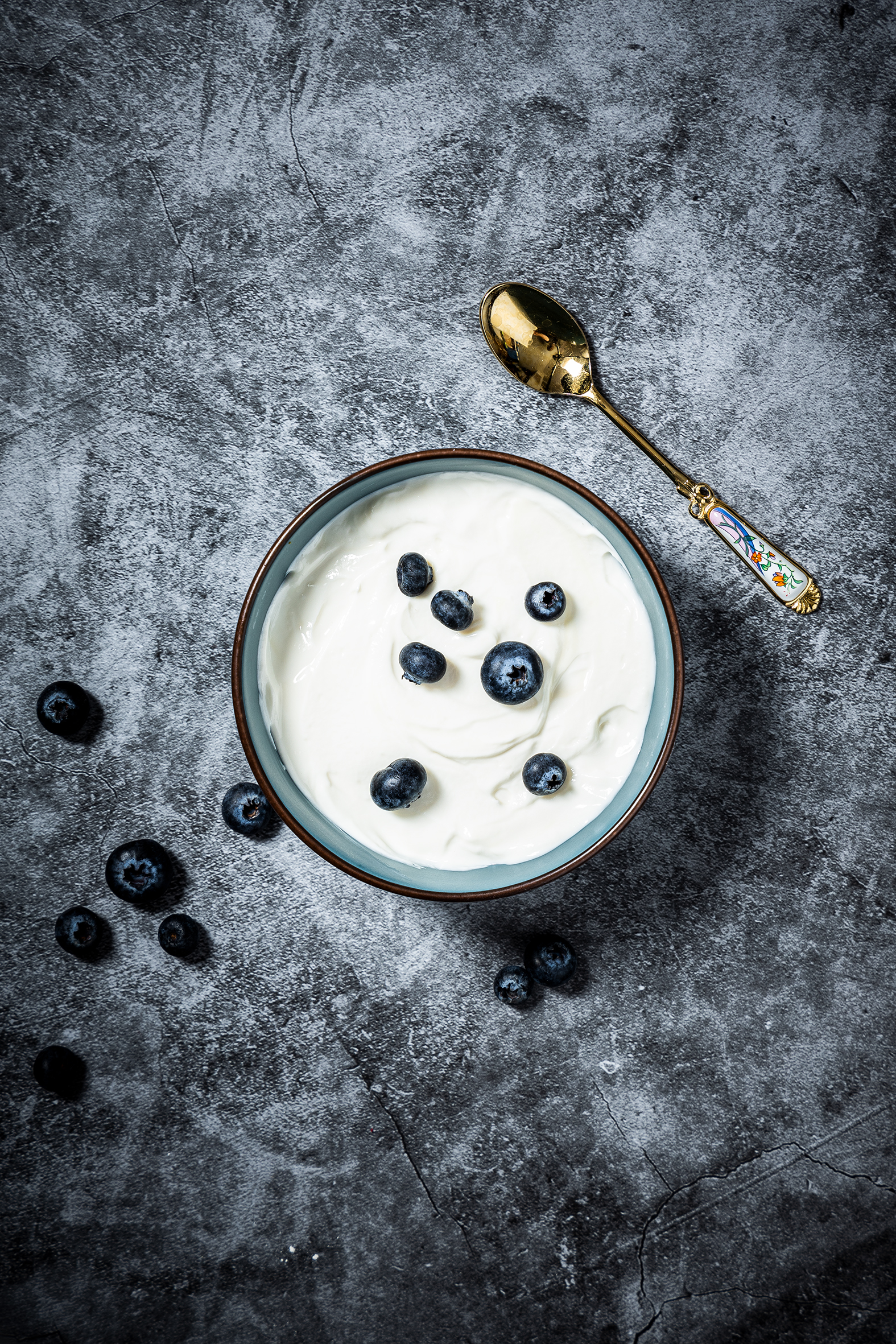Foodfotografie mit Blaubeeren und Joghurt auf dunklem Untergrund